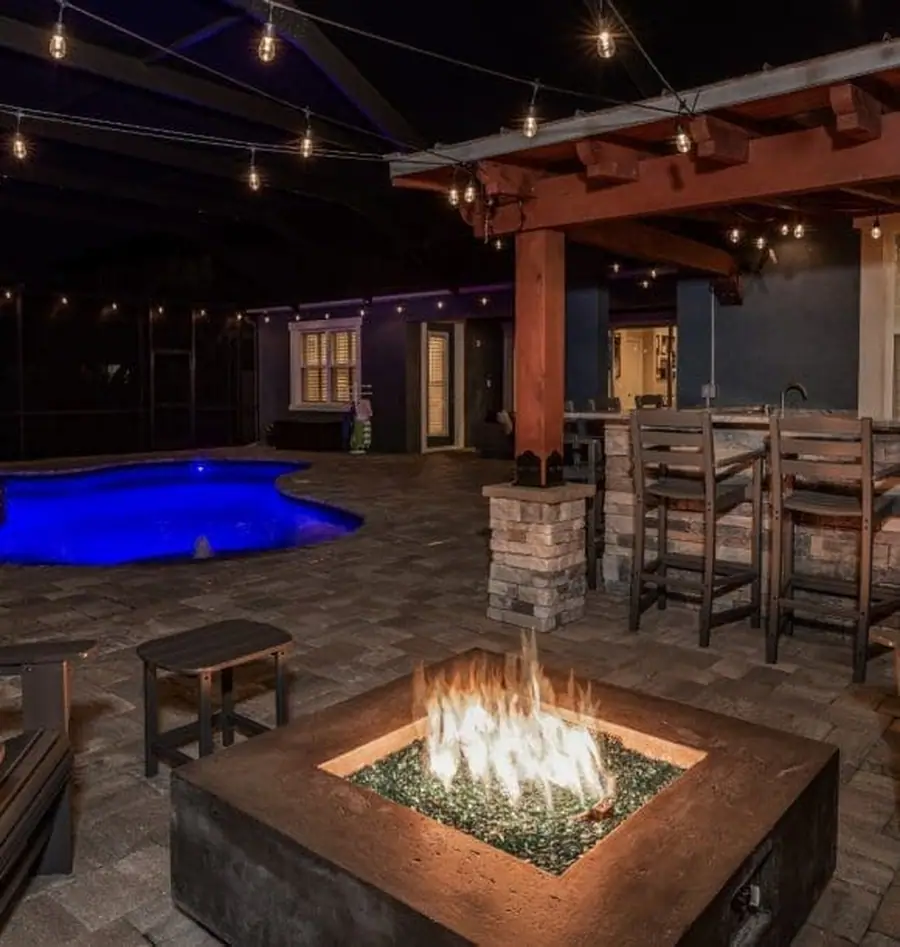 Outdoor kitchen and pool at dusk